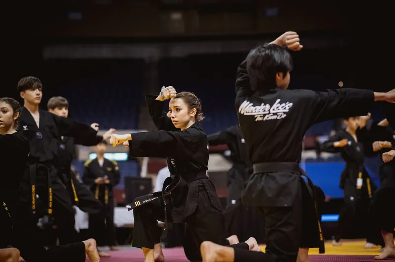 Demo Team members in black uniforms in a performance stance