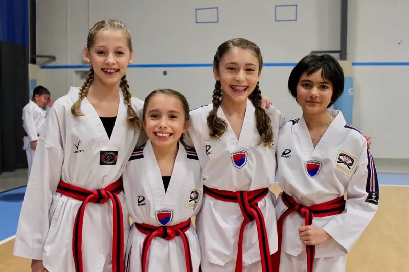 Four smiling students in Master Lee’s uniforms