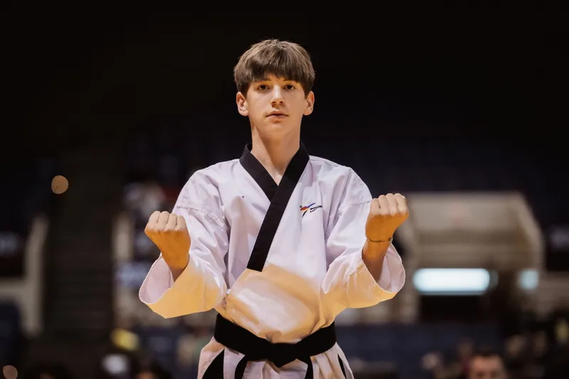 A teen student in uniform in a ready stance